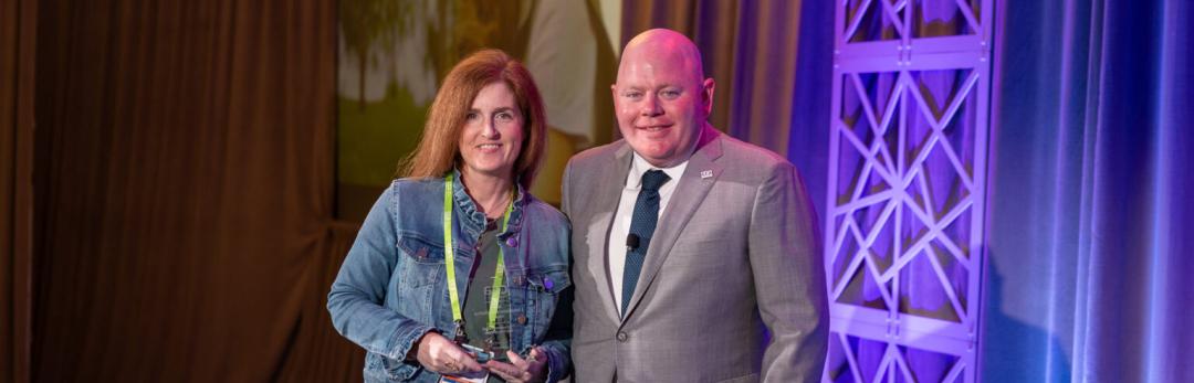 CEO of Cellcom, Brighid Riordan, accepting an award on stage.