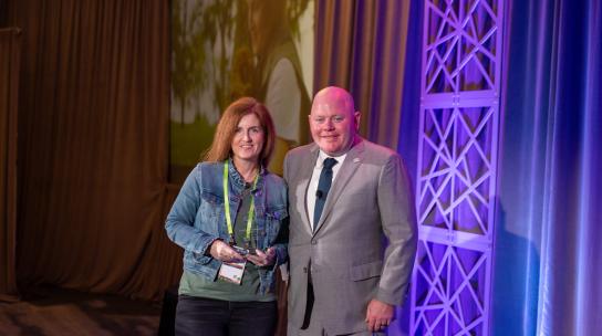 CEO of Cellcom, Brighid Riordan, accepting an award on stage.