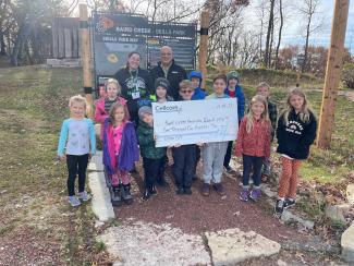 Group holds donation check as part of Cellcom's Green Gift program