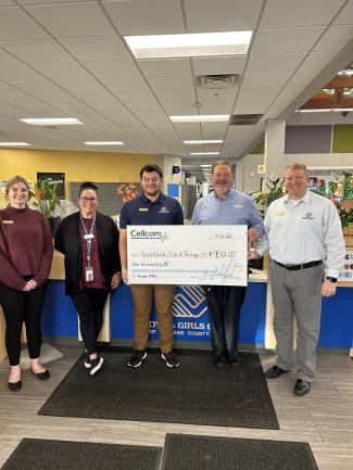 Group holds donation check as part of Cellcom's Green Gift program