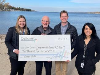 Group of four holding donation check for Cellcom's Green Gift program.