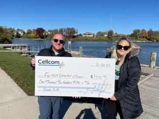 Two people holding a donation check for Cellcom's Green Gifts program.