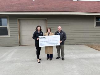 Group of three holding a donation check for Cellcom's Green Gifts.