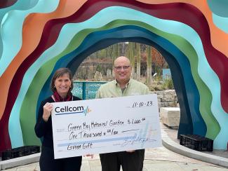 Two people holding a donation check for Cellcom's Green Gifts program.