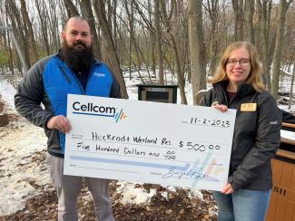 Two people holding a donation check for Cellcom's Green Gifts