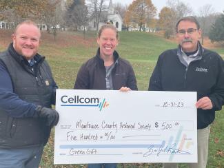 Group of three holding donation check for Cellcom's Green Gifts