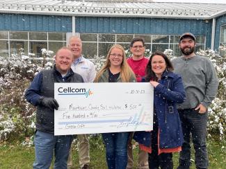 Group of six holding a large donation check for Green Gifts.
