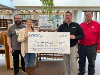 Group of four holding a donation check for Cellcom's Green gifts.