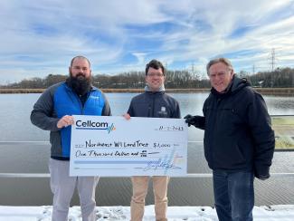 Three people holding a donation check for Cellcom's Green Gift