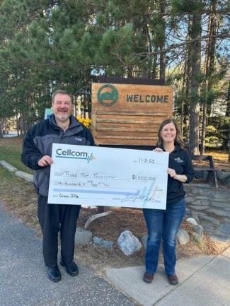 Two people holding a donation check for Cellcom's Green Gifts program.