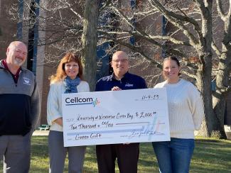 Group of four holding a donation check for Cellcom's Green gifts.