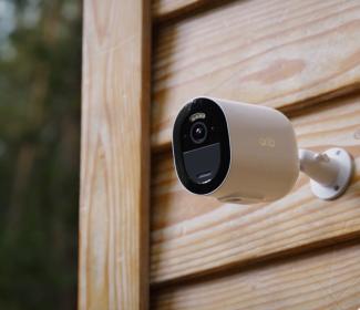 Arlo security camera mounted to the wood siding of a cabin