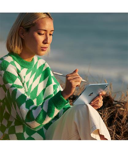 A woman using an iPad mini with an Apple Pencil Pro.