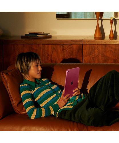 A child sitting on a couch using the iPad.